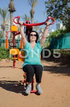Woman grabbing the bar of lat pull machine Stock Photos