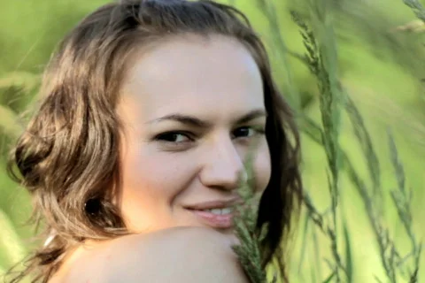 Woman in grassfields flirting with camera Stock Footage 785679