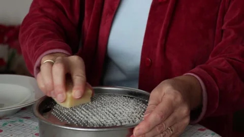 Woman Grating Cheese using Cheese Grater Stockbeeldmateriaal 151852074
