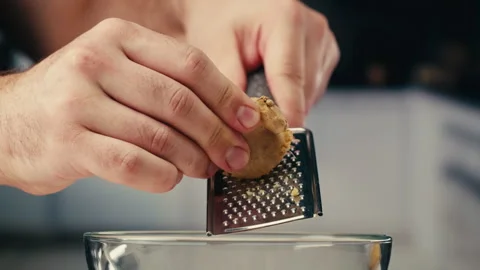 Woman grating ginger on black background, grater with ginger for healthy tea Stock Footage 309633652