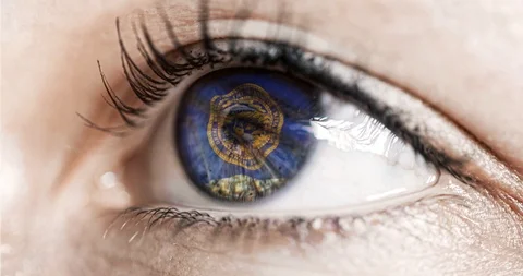 Woman green eye in close up with the flag of Mebraska state in iris, united stat Video stock 120076341