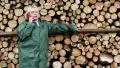 Woman in green slicker standing near timber, talking telephone HD Footage