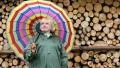 Woman in green slicker stands near lumber and smiling HD Footage