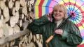 Woman in green slicker with umbrella and cell phone HD Footage
