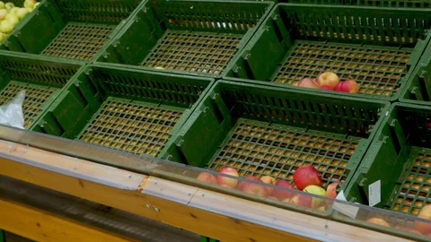 Woman with a grocery cart drives past empty fruit shelves Stock Footage