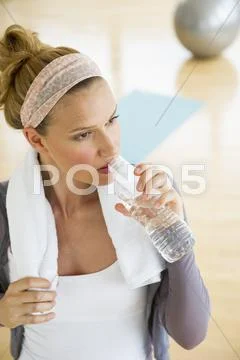 Woman in gym drinking water Stock Photos