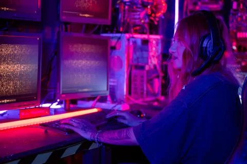 Woman hacker sitting in front of a computer typing on keyboard hacking serv.. Foto stock