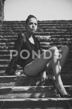 Woman with hair bun enjoy sunny day, vogue. Woman relax stairs, fashion. Girl Stock Photos