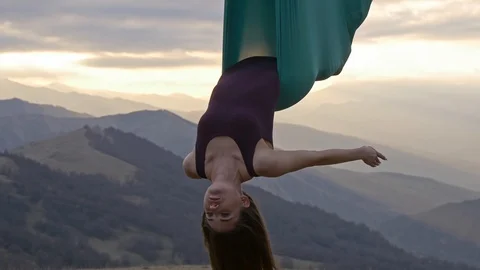 Woman in hammock meditating upside down at sunset Stock Footage 88624662