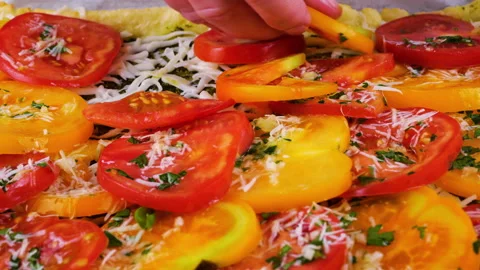 Woman hand adding fresh red and yellow tomato slices onto cottage cheese dough.  Stock Footage 341523562