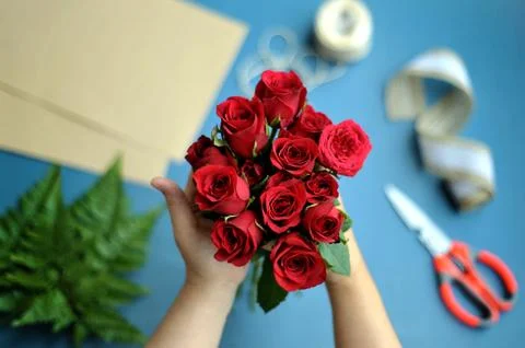 A woman hand arrange the fresh red roses for bouquet Stock Photos