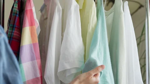 Woman hand checking clothes hanging on rail. Stock Footage 221562553