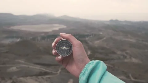 Woman hand with a compass in front of mountain valley. Stock Footage 146154598