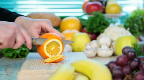 Woman hand cutting orange Stock Footage