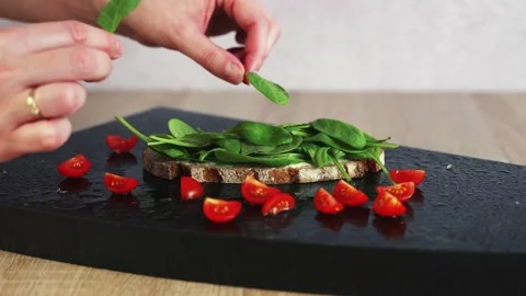 Woman hand decorated a slice bread with spinach Stock Footage 206087262