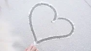 Woman Hand Drawn Romantic Heart Shape On Snow. Slow Motion Stock Footage