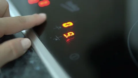 Woman hand includes modern induction stove, close up Stock Footage 103175053