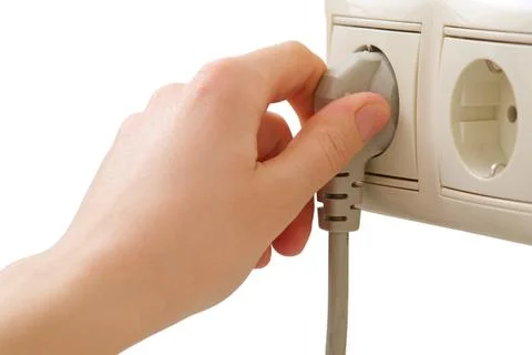 Woman hand inserting electrical plug into wall socket isolated on white backg Stock Photos