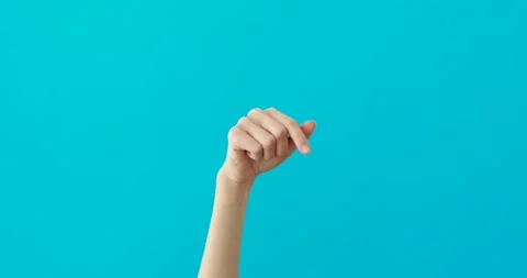 Woman hand points down by elegant finger on turquoise Vídeos de archivo 150624394
