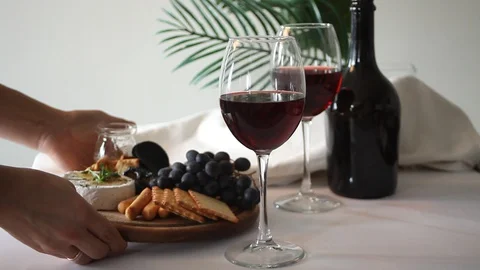 Woman hand put a plate with assorted cheese, fruit and other snacks for party. Stock Footage 128414769