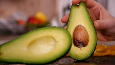 Woman hand separating the two halves of avocado - slow motion 動画素材 101862934
