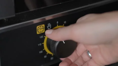 Woman hand setting temperature control on oven Stock Footage 67001406