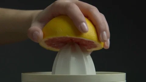 Woman Hand with Squeezer Squeezing Grapefruit Juice Isolated Grey Background Stock Footage 76521504
