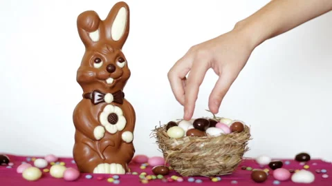 Woman hand taking easter almonds eggs from nest on table with easter decorati Stock Footage 126678671