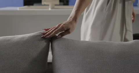 Woman hand touch pillow on sofa in living room. Young female hands gently touch Stock Footage 276229280