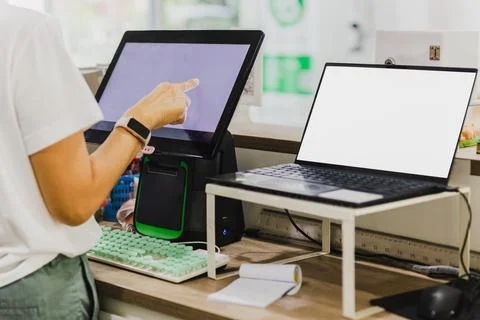 Woman hand touching computer creen at cashier counter. Stock Photos