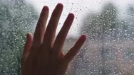 Woman Hand Is Touching A Wet Glass With Rain Drops. Stock Footage