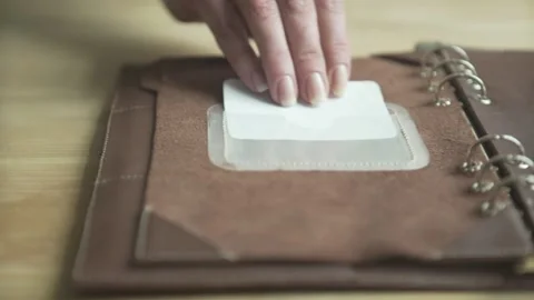 Woman hand using elegant light brown leather case daily planner habit tracker no Stock Footage 137538985