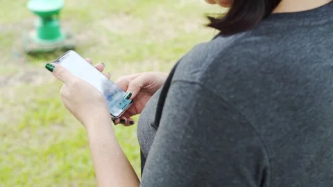 Woman hand using mobile smart phone in the park. 스톡 동영상 114725334