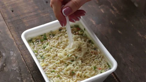 Woman hand using plastic fork eating hot instant noodles in food container Stock Footage 129000185
