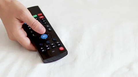 Woman hand using remote control from tv pressing the ok or volume button Stock Footage 202600464