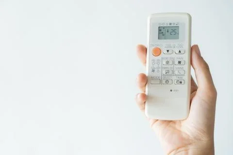 Woman hand using remote control open air conditioning 25 degrees Foto stock