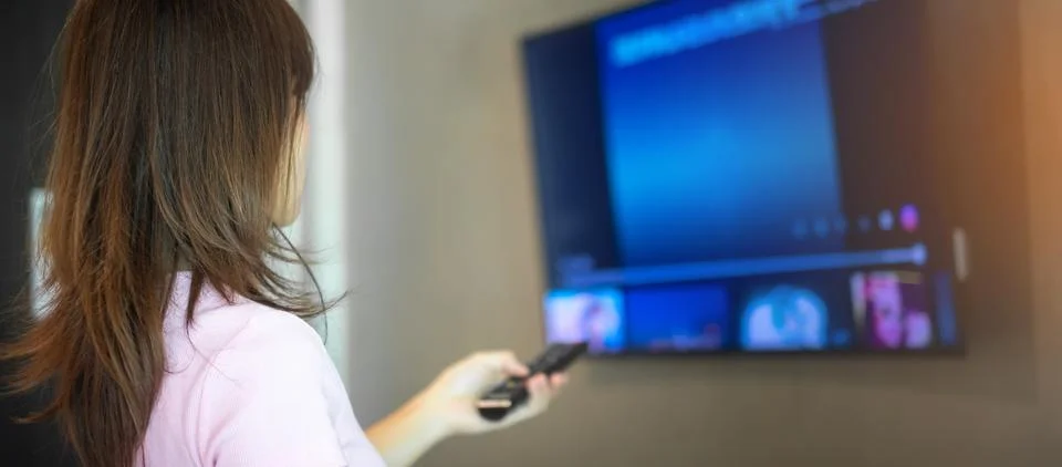 Woman hand using remote controller for adjust Smart TV inside the modern ro.. Stock Photos