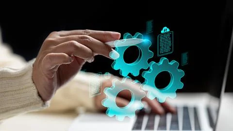 A woman hand using a stylus to interact with glowing blue virtual gears and.. Stock Photos