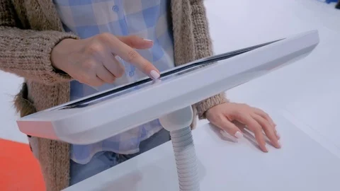 Woman hand using touchscreen display of floor standing white tablet kiosk Stock Footage 119448294