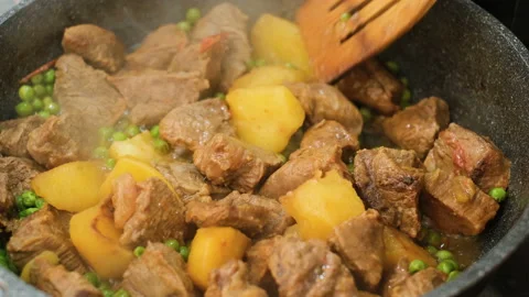 Woman hand while cooking beef meat stew with potatoes close up,homemade food Stock Footage 161357541