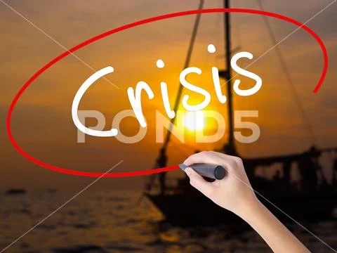 Woman Hand Writing Crisis with a marker over transparent board Stock Photos