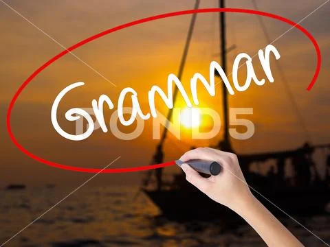 Woman Hand Writing Grammar with a marker over transparent board Stock Photos