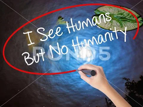 Woman Hand Writing I See Humans But No Humanity with marker over Stock Photos