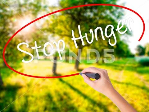 Woman Hand Writing Stop Hunger with a marker over transparent b Stock Photos
