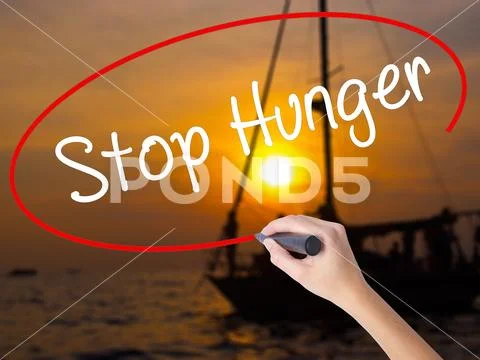 Woman Hand Writing Stop Hunger with a marker over transparent b Stock Photos