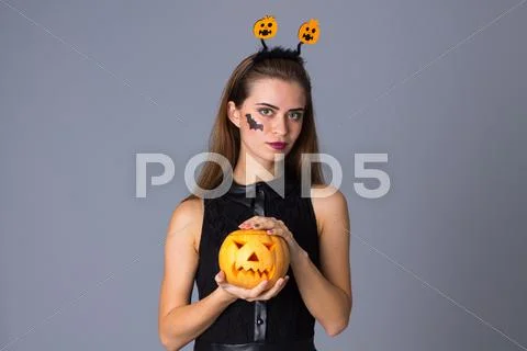 Woman with handband holding a pumpkin Stock Photos