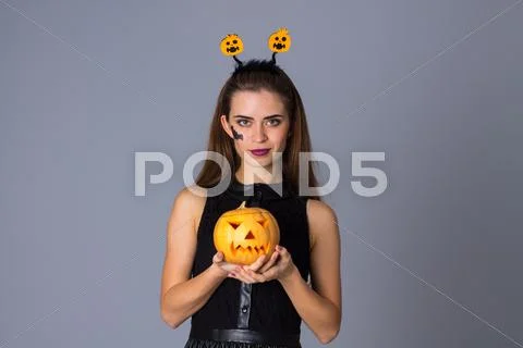 Woman with handband holding a pumpkin Stock Photos