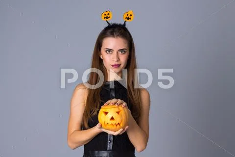 Woman with handband holding a pumpkin Stock Photos