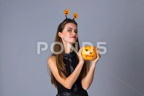 Woman with handband holding a pumpkin Stock Photos