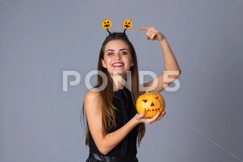 Woman with handband holding a pumpkin Stock Photos